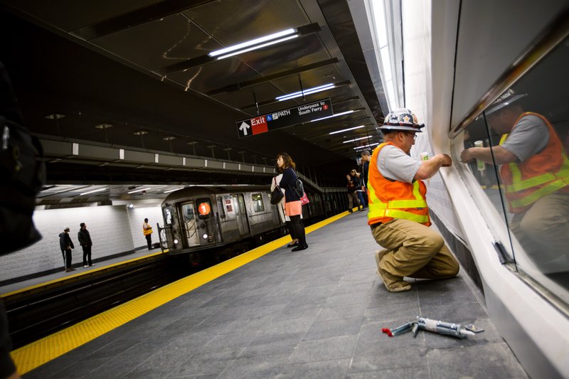 A worker caulks a window at a subway station in New York on Sept. 10, 2018. 