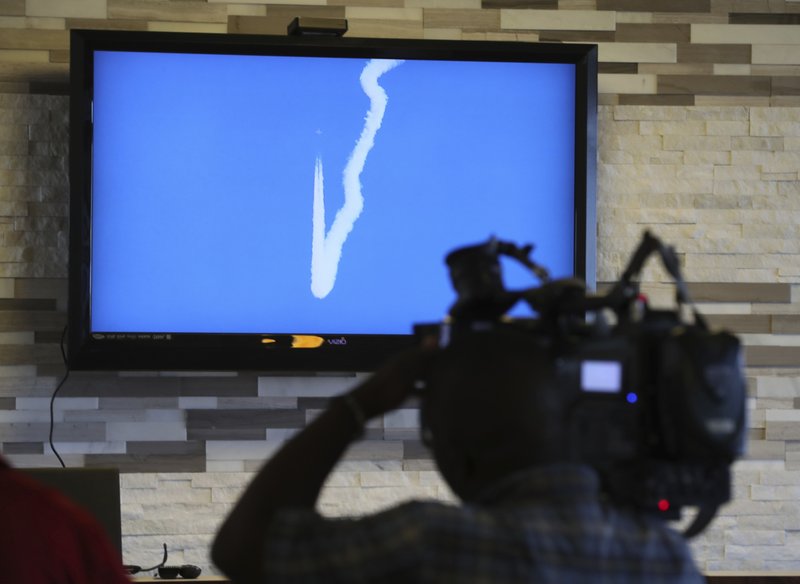 In this April 17, 2018 photo, a NASA image of a F/A-18 performing a Sonic Boom over Edwards Air Force Base in California, is shown on a TV screen in Galveston, Texas. NASA has begun a series of supersonic research flights off the Texas Gulf Coast near Galveston to test how the community responds to noise from a new experimental aircraft. (Steve Gonzales/Houston Chronicle via AP)