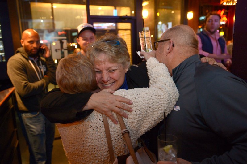 Denise Garner, winner of State House District 84, gets a hug Tuesday as she enters the room during a watch party for the Washington County Democratic Party of Arkansas at Farrell’s Lounge in Fayetteville.

