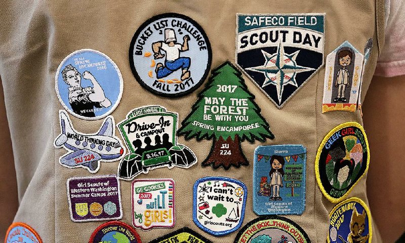 A Girl Scout shows off the patches on her vest recently. The Girl Scouts of the United States of
America has filed suit against the Boy Scouts of America for dropping the word “boy.”