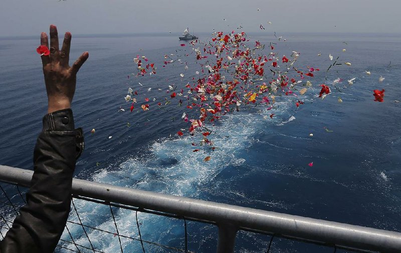 A relative on an Indonesia navy ship sprinkles flowers Tuesday during a prayer for the victims of the Lion Air Flight 610 in the waters where the airplane is believed to have crashed in Tanjung Karawang, Indonesia.