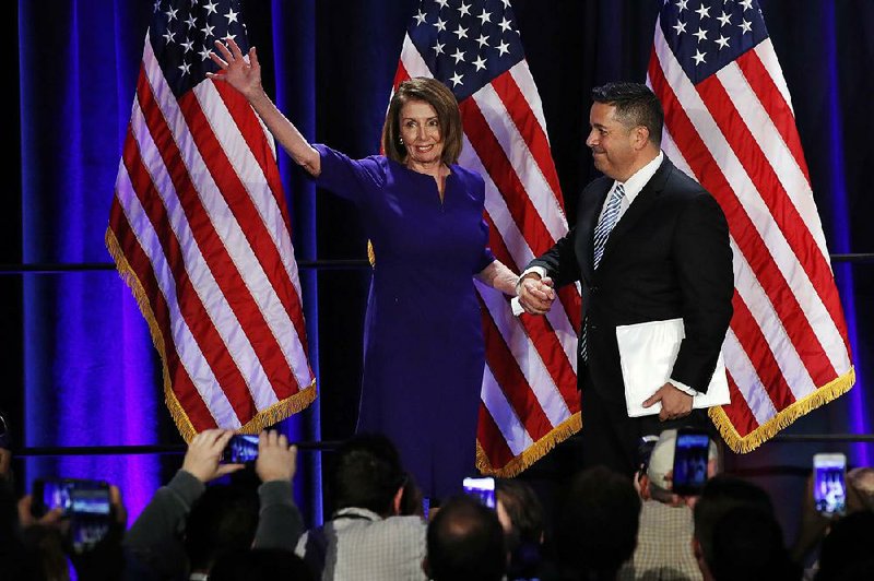 House Democratic Leader Nancy Pelosi joins a victory party Tuesday in Washington with Ben Ray Lujan, head of the party’s campaign committee. “Tomorrow will be a new day in America,” Pelosi said. 
