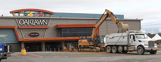 The Sentinel-Record/Richard Rasmussen UNDER CONSTRUCTION: A backhoe dumps a load of dirt into a truck Wednesday in the parking lot at Oaklawn Racing and Gaming as part of improvement projects that have been taking place since this summer.