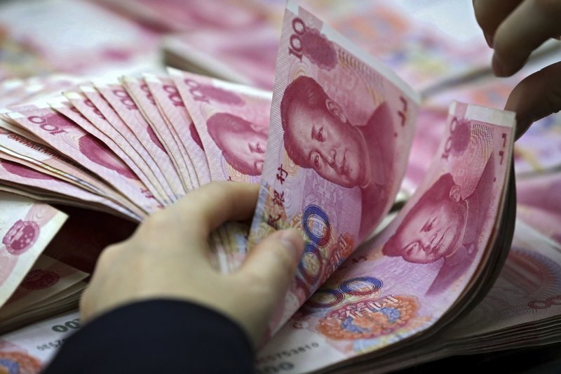  In this Nov. 25, 2016, file photo, a clerk counts Chinese currency notes at a bank outlet in Huaibei in central China's Anhui province. China's foreign currency reserves declined in October, 2018, suggesting Beijing might be intervening in market to keep its yuan's politically sensitive exchange rate from falling to far against the dollar. (Chinatopix via AP, File)