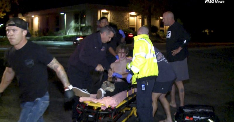 In this image taken from video a victim is treated near the scene of a shooting, Wednesday evening, Nov. 7, 2018, in Thousand Oaks, Calif. A hooded gunman dressed entirely in black opened fire on a crowd at a country dance bar holding a weekly "college night" in Southern California, killing multiple people and sending hundreds fleeing including some who used barstools to break windows and escape, authorities said Thursday. The gunman was later found dead at the scene. (RMG News via AP)