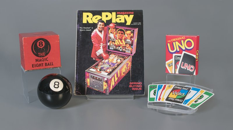 This October 2018 photo provided by The Strong museum shows the toys to be inducted into the National Toy Hall of Fame, inside the Rochester, N.Y., museum. The class of 2018 honored Thursday, Nov. 8, includes, from left, the Magic 8 Ball, pinball and the card game Uno. (Victoria Gray/The Strong via AP)

