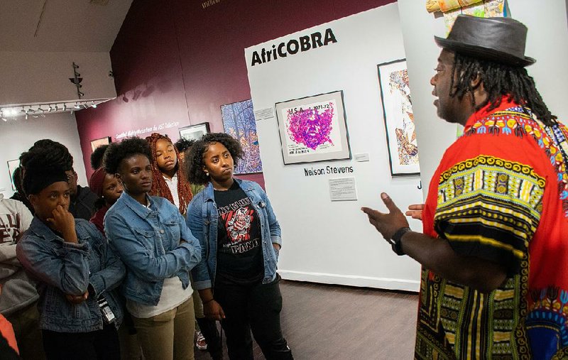 Kevin Cole talks to a group of Pine Bluff High School students at the Arts & Science Center for Southeast Arkansas during a reception for the installation of his sculpture at the museum. 