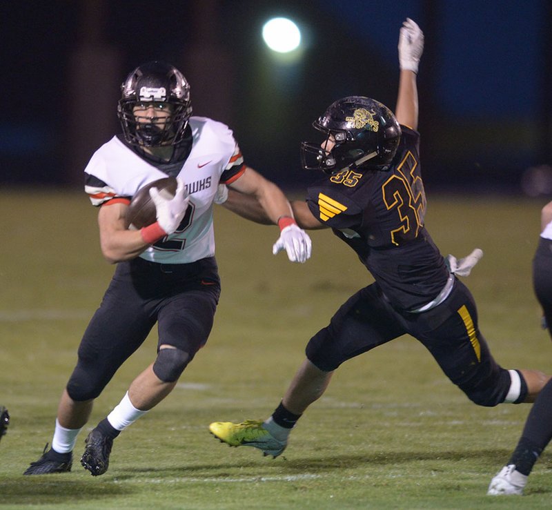 NWA Democrat-Gazette/ANDY SHUPE Pea Ridge running back Samuel Beard (left) carries the ball past Prairie Grove linebacker Jared Harger Friday, Oct. 12, 2018, during the first half at Tiger Stadium in Prairie Grove. The Blackhawks will host Helena-West Helena Central in the first round of the Class 4A playoffs.
