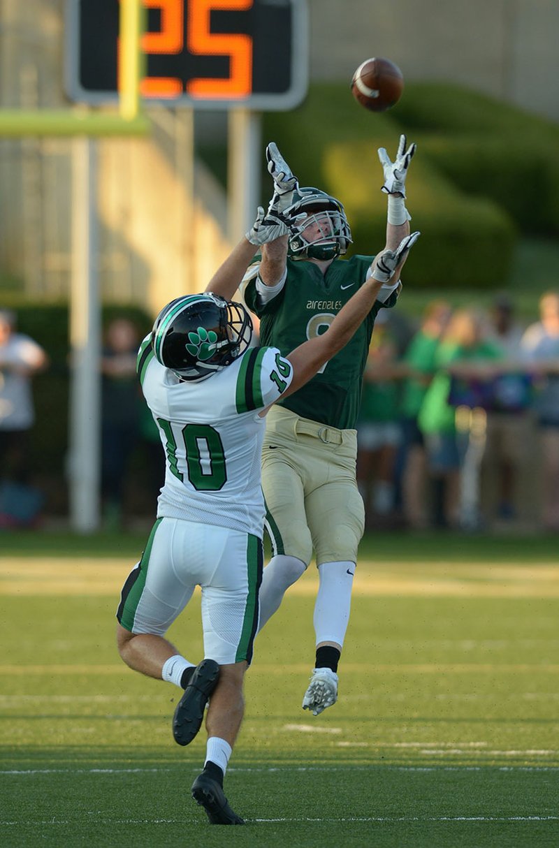 NWA Democrat-Gazette/ANDY SHUPE Alma receiver Grayson Bailey (right) reaches to make a catch behind Van Buren defender David Evans Tuesday, Aug. 28, 2018, during the first half at Airedale Stadium in Alma. The Airedales will travel to take on No. 1 Pulaski Academy in a first-round playoff game.