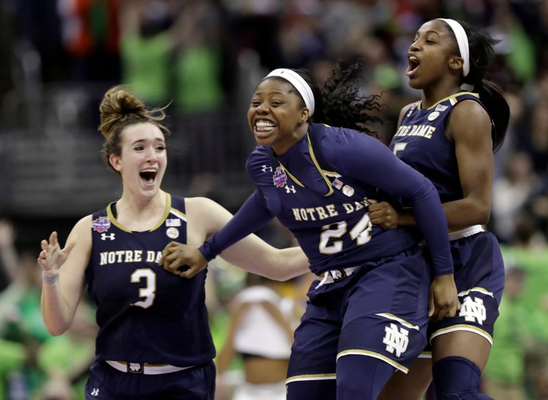  In this Sunday, April 1, 2018 file photo, Notre Dame's Arike Ogunbowale, center, is congratulated by teammates Jackie Young, right, and Marina Mabrey (3) after sinking a 3-point basket to defeat Mississippi State 61-58 in the final of the women's NCAA Final Four college basketball tournament in Columbus, Ohio. Arike Ogunbowale and Marina Mabrey will always have Columbus, Ohio.  (AP Photo/Tony Dejak, File)