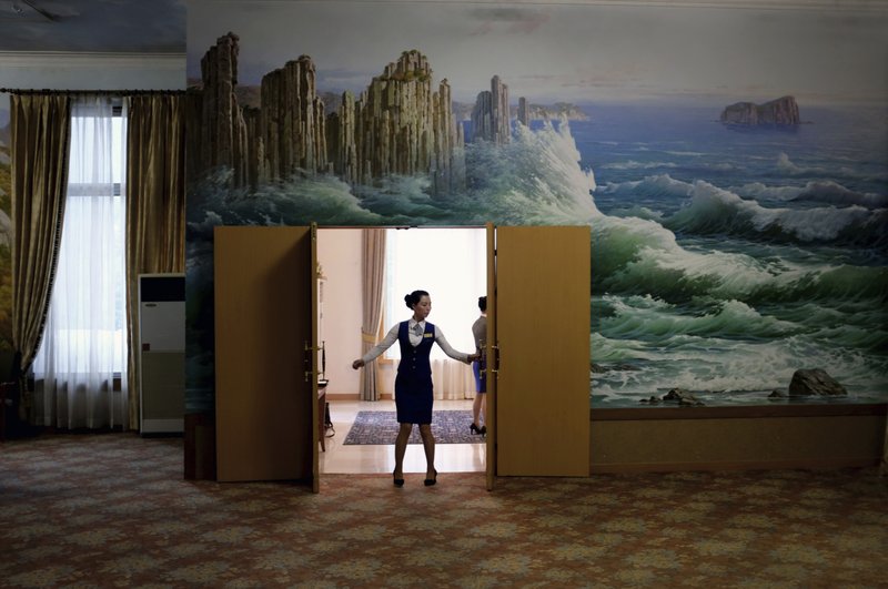 In this Tuesday, Oct. 23, 2018, photo, a staff member closes the doors of a meeting room at the Kumgangsan Hotel at the Mount Kumgang resort area which was once a popular destination for South Korean tourists, in North Korea. A decade after the North-South experiment in tourism cooperation in Kumgang ended in bitter failure following the fatal shooting of a South Korean tourist in 2008, North Korean leader Kim Jong Un and South Korean President Moon Jae-in want to give it another try amid opposition from Washington. (AP Photo/Dita Alangkara)