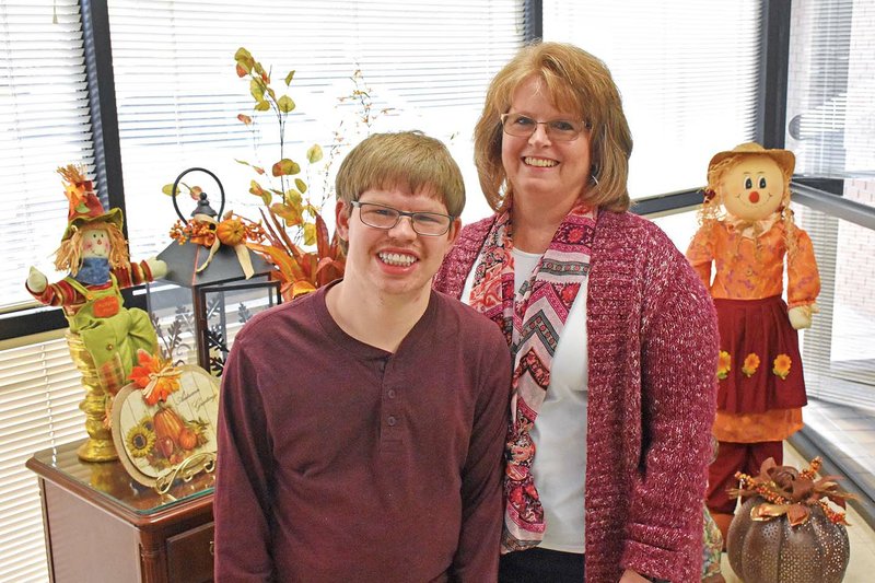 Garrett Ellsworth, 24, stands with his mother, Cynthia Ellsworth, at the Mid-Arkansas River Valley Abilities Workshop in Russellville, where he works three days a week. Cynthia is a member of the board of directors of the nonprofit organization that provides jobs for people with intellectual and developmental disabilities. It will celebrate its 50th anniversary with an open house from 2-4 p.m. Thursday at the center, 1205 S. Arkansas Ave.