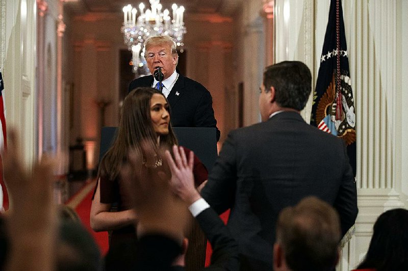 A White House intern reaches to take the microphone away from CNN correspondent Jim Acosta during a Nov. 7 news conference.