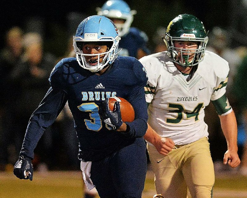 Pulaski Academy running back Izarius Woods (left) runs away from Alma linebacker Gabe Jensen during the Bruins’ 57-21 victory over the Airedales on Friday in the first round of the Class 5A playoffs. For more high school football photos, visit arkansasonline.com/galleries.