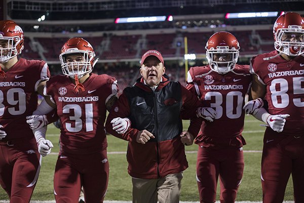 Arkansas coach Chad Morris and players walk arm-in-arm down the field prior to a game against LSU on Saturday, Nov. 10, 2018, in Fayetteville. 