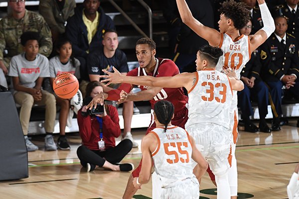 Arkansas forward Daniel Gafford passes the ball while he is guarded by multiple Texas players during the Armed Forces Classic on Friday, Nov. 9, 2018, in El Paso, Texas. 