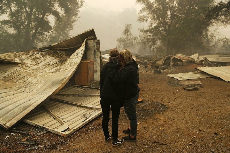 Krystin Harvey (right) comforts her daughter Araya Cipollini as they look at the remains of their home Saturday in Paradise, Calif. Much of Paradise was destroyed last week by the Camp wildfire, which has claimed more than 6,700 homes and commercial buildings.