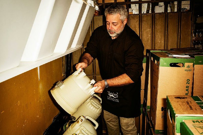 Jimmy Streit handles a DraughtMaster plastic keg in the cellar of his bar in Copenhagen, Denmark. 