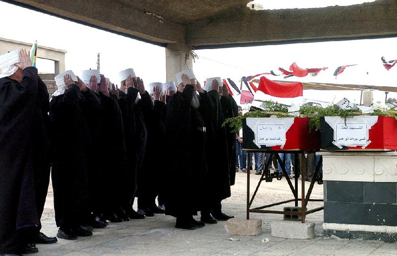 Clergymen from Syria’s Druze minority pray Saturday in Sweida province at a funeral ceremony for captives who were killed by Islamic State militants.