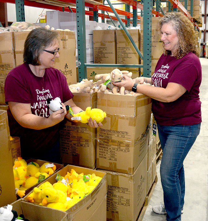 Janelle Jessen/Siloam Sunday Terri Black, left, DaySpring Outlet Store cashier and warehouse sale site manager, and Sherri Brooker, Outlet Store manager and warehouse sale coordinator, priced items on Friday in preparation for the annual Dayspring warehouse sale. Last year, more than 6,000 people attended the sale, some traveling from as far away as New Mexico, Indiana and Nebraska.