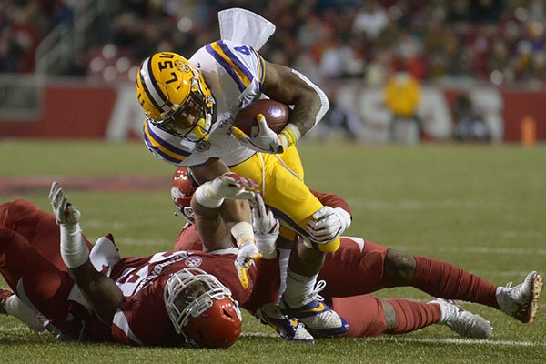 Arkansas linebackers De'Jon Harrs (right) and Dre Greenlaw take down LSU running back Nick Brossette Saturday, Nov. 10, 2018, during the second quarter of play at Razorback Stadium in Fayetteville. 