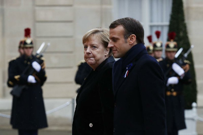 French President Emmanuel Macron (right) and German Chancellor Angela Merkel arrive for lunch at Elysee Palace in Paris after ceremonies marking the 100th anniversary of the end of World War I. 