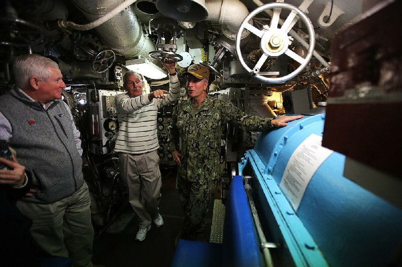 Greg Zonner (center), executive director of the Arkansas Inland Maritime Museum, gives a tour of the USS Razorback submarine to Rear Adm. Brian Fort (right), commander of Navy Region Hawaii Naval Surface Group Middle Pacific, on Sunday in North Little Rock. 