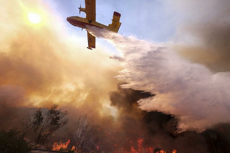 An air tanker drops water Monday onto a wildfire burning near California Highway 118 in Simi Valley, Calif. 