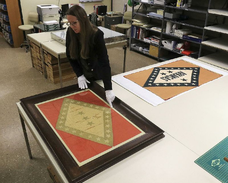 Julienne Crawford, curator at the Arkansas State Archives, talks about the repairs that conservators will make to two early Arkansas state flags, including the original state flag on the left that dates to 1913. 