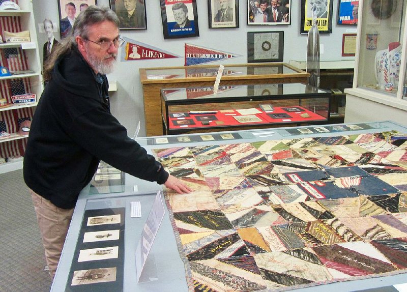 Mike Polston, director of the Museum of American History in Cabot, traces the background of a World War I quilt on display.