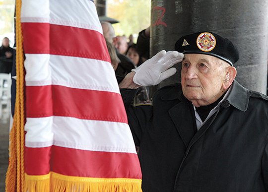 The Sentinel-Record/Richard Rasmussen OLD GLORY: Ralph King, a World War II veteran and member of the VFW Post 2278 color guard, salutes the flag at the Garland County Veterans Day service at the Hot Springs Farmers &amp; Artisans Market, across the street from the Garland County Veterans Memorial and Military Park, on Monday.