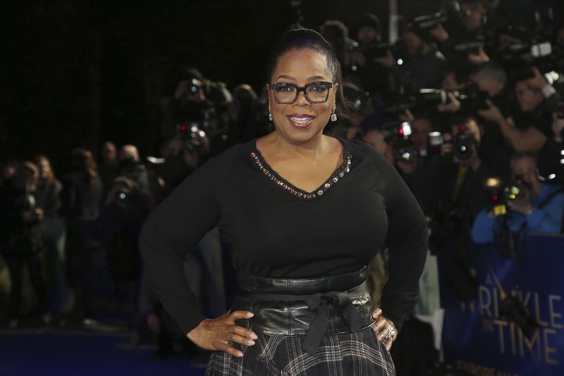 FILE - In this March 13, 2018, file photo, actress Oprah Winfrey poses for photographers upon arrival at the premiere of the film 'A Wrinkle In Time' in London. Winfrey has chosen Michelle Obama&#x2019;s &#x201c;Becoming&#x201d; as her next book club pick, The Associated Press has learned. In a statement Monday, Nov. 12, Winfrey said the memoir was &#x201c;well-written&#x201d; and inspirational. (Photo by Joel C Ryan/Invision/AP, File)