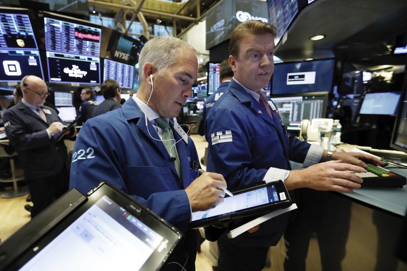 FILE- In this Nov. 7, 2018, file photo trader Timothy Nick, center, works with specialist Michael O'Mara on the floor of the New York Stock Exchange. The U.S. stock market opens at 9:30 a.m. EDT on Monday, Nov. 12. (AP Photo/Richard Drew, File)