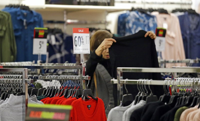 FILE- In this Nov. 24, 2017, file photo a shopper looks over clothing at a JC Penney store on Black Friday in Seattle. A solid 70 percent of Americans plan to shop on Black Friday this year, according to a recent NerdWallet study conducted by The Harris Poll. (AP Photo/Elaine Thompson, File)