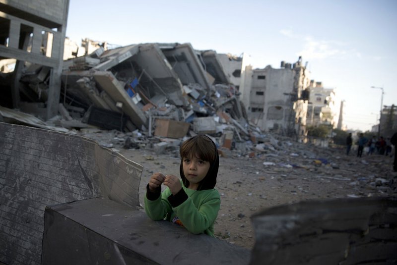 A Palestinian boy stands next to the rubble of Hamas' Al-Aqsa TV station building which was hit by Israeli airstrikes on Monday, in Gaza City, Tuesday, Nov. 13, 2018. (AP Photo/Khalil Hamra)