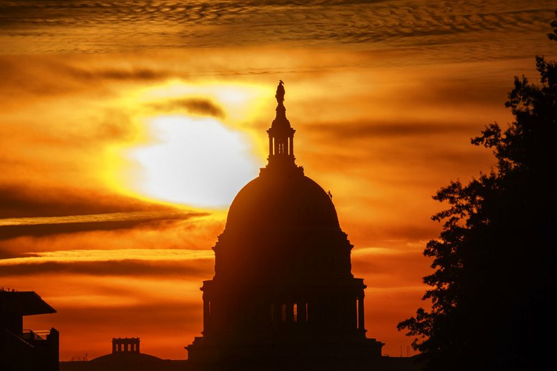 FILE- In this Oct. 26, 2018, file photo the rising sun silhouettes the U.S. Capitol dome at daybreak in Washington. The Treasury Department issues a report Tuesday, Nov. 13, on how much money Uncle Sam took in and paid out last month. (AP Photo/Alex Brandon, File)