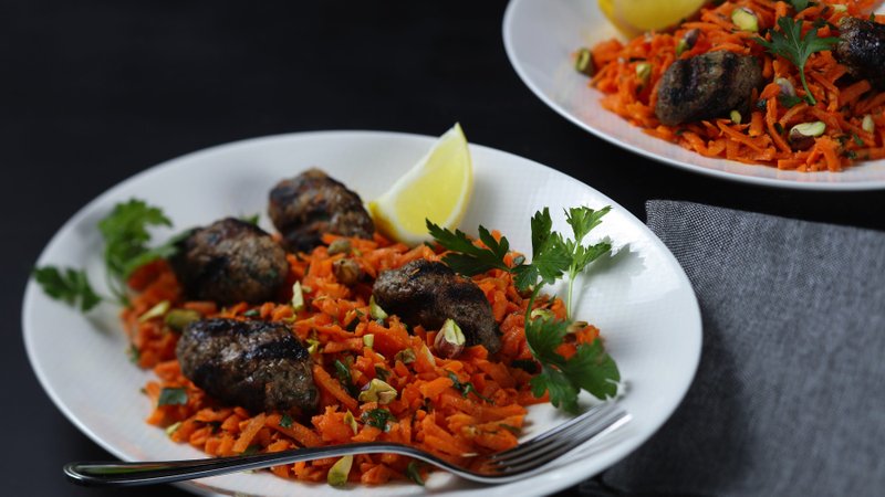 Kefta, made with ground lamb, grated onion, and chopped mint and parsley, are served on a crisp salad of grated carrots with lemon-honey-chile dressing.