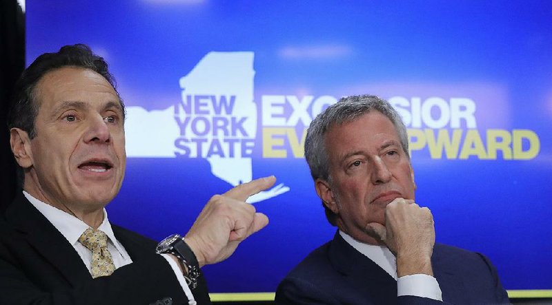 New York City Mayor Bill de Blasio, right, listens as New York Gov. Andrew Cuomo speaks during a news conference Tuesday Nov. 13, 2018, in New York. Amazon said it will split its much-anticipated second headquarters between New York and northern Virginia. Its New York location will be in the Long Island City neighborhood of Queens. (AP Photo/Bebeto Matthews)