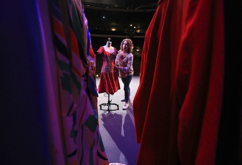 Anna Kimmell, director of education at The Arkansas Repertory Theatre, moves props into place Tuesday afternoon on the stage in preparation for an event to announce details of an abbreviated season of plays and musicals. 