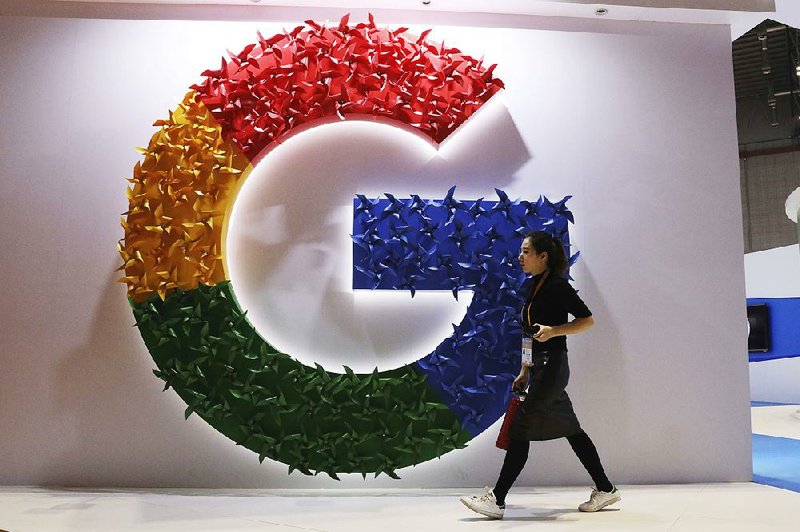 A woman walks past the Google logo at the China International Import Expo in Shanghai last week. A Nigerian Internet service provider’s error caused a disruption in several Google services Monday, including search and cloud-hosting services. 