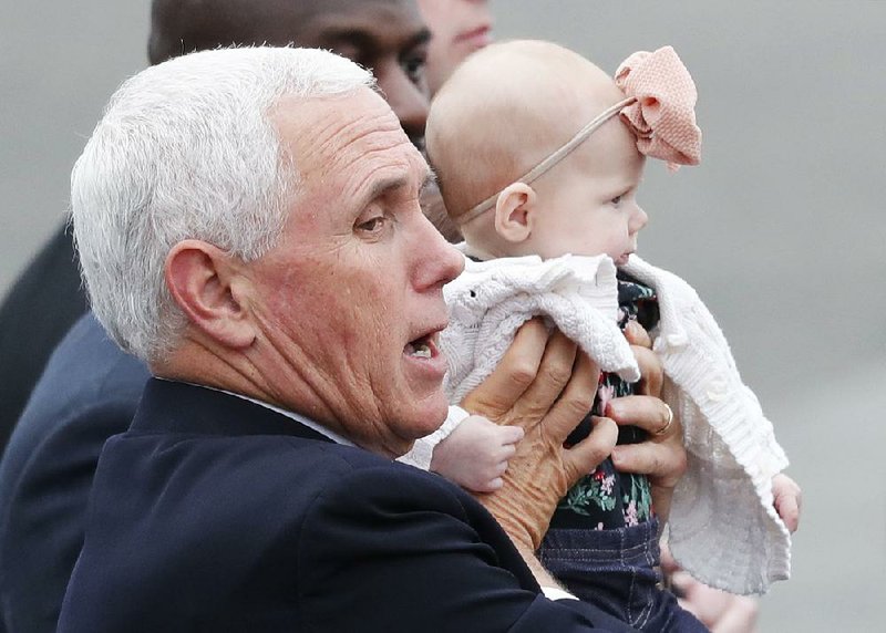 Vice President Mike Pence holds a baby Tuesday during a visit to U.S. servicemen at Yokota Air Force Base in Fussa, on the outskirts of Tokyo. 