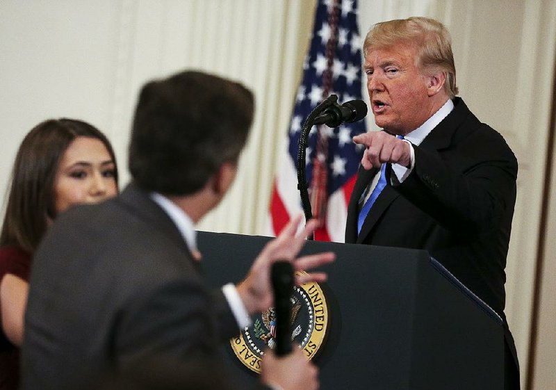 A White House intern reaches for the microphone on Nov. 11 as President Donald Trump rebuffs a question from CNN correspondent Jim Acosta. 
