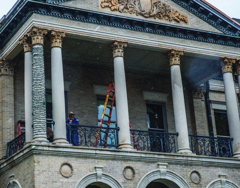 Workers Tuesday morning in Magnolia deal with snowy conditions as they prepare the Columbia County Courthouse for its annual seasonal Christmas lighting.