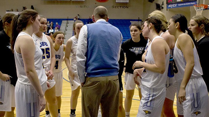 Photo courtesy of JBU Sports Information John Brown women's basketball players listen as head coach Jeff Soderquist gives instructions during last Saturday's game against Ecclesia.
