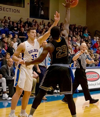 Photo courtesy of JBU Sports information John Brown senior Josh Bowling tries to make a play against Ecclesia last Saturday night as Royals guard De'Vontae Ross defends on the play.