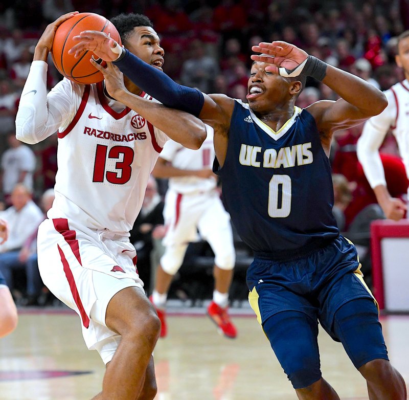 NWA Democrat-Gazette/J.T. Wampler SOPHOMORE GRAB: Arkansas sophomore transfer Mason Jones (13) snatches a rebound in front of UC-Davis' T.J. Shorts II (0) Monday during the Razorbacks' 81-58 victory in their home opener at Bud Walton Arena in Fayetteville.