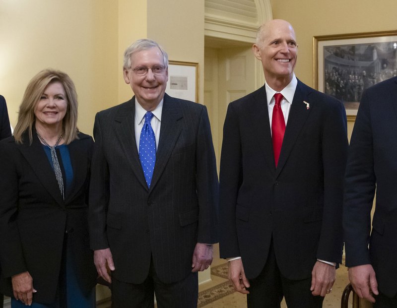 Senate Majority Leader Mitch McConnell, R-Ky., center, is flanked by Rep. Marsha Blackburn, R-Tenn., left, the senator-elect from Tennessee, and Florida Gov. Rick Scott, the Republican candidate in the undecided challenge to incumbent Sen. Bill Nelson, D-Fla., during a meeting with new GOP senators at the Capitol in Washington, Wednesday, Nov. 14, 2018. (AP Photo/J. Scott Applewhite)