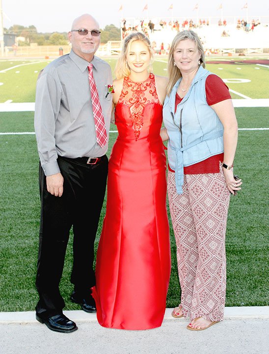 MARK HUMPHREY ENTERPRISE-LEADER Greg and Alicia Goldman, of Evansville, pictured with daughter Jessica (center) during Lincoln's 2017 Homecoming ceremony; will miss Jessica's Friday game when Lincoln plays at border rival, Westville, Okla. -- because the Goldmans have opportunity to travel to the U.S. Virgin Islands and watch their son, Shandon, a 2015 Lincoln graduate, compete as a member of the Northern Iowa men's basketball team in the Paradise Jam tournament.