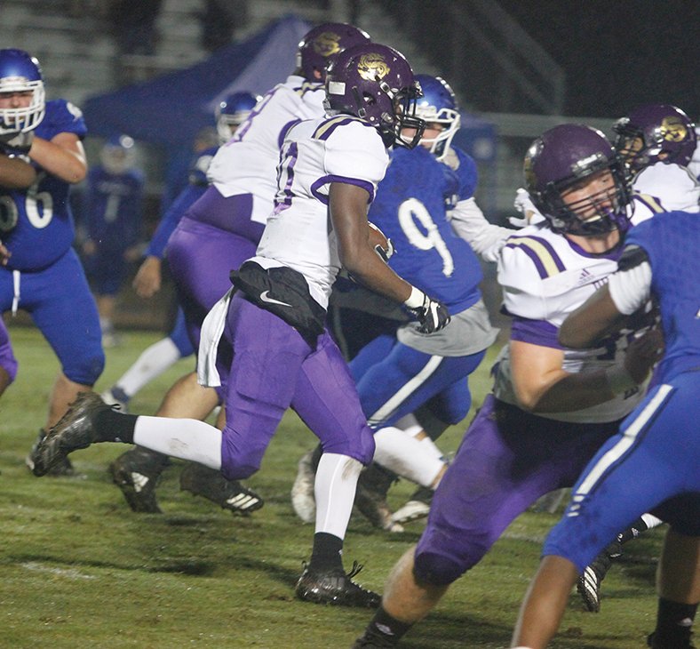 Terrance Armstard/News-Times Junction City running back Dhante Gibson runs through a hole during the Dragons' 8-2A contest against Parkers Chapel earlier this month at Victor Nipper Stadium. On Friday night, Junction City plays host to Mountainburg in the second round of the 2A playoffs.