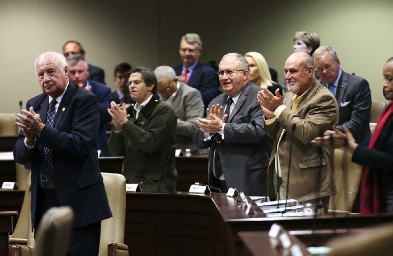 Lawmakers applaud Wednesday as Gov. Asa Hutchinson leaves the room after presenting his proposed state budget.